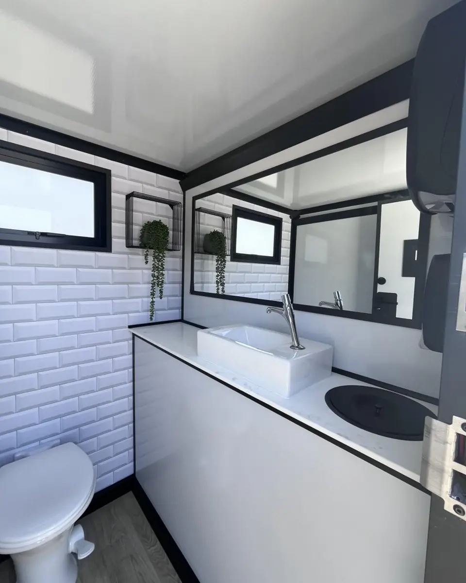 Sink and wide mirror inside a restroom trailer