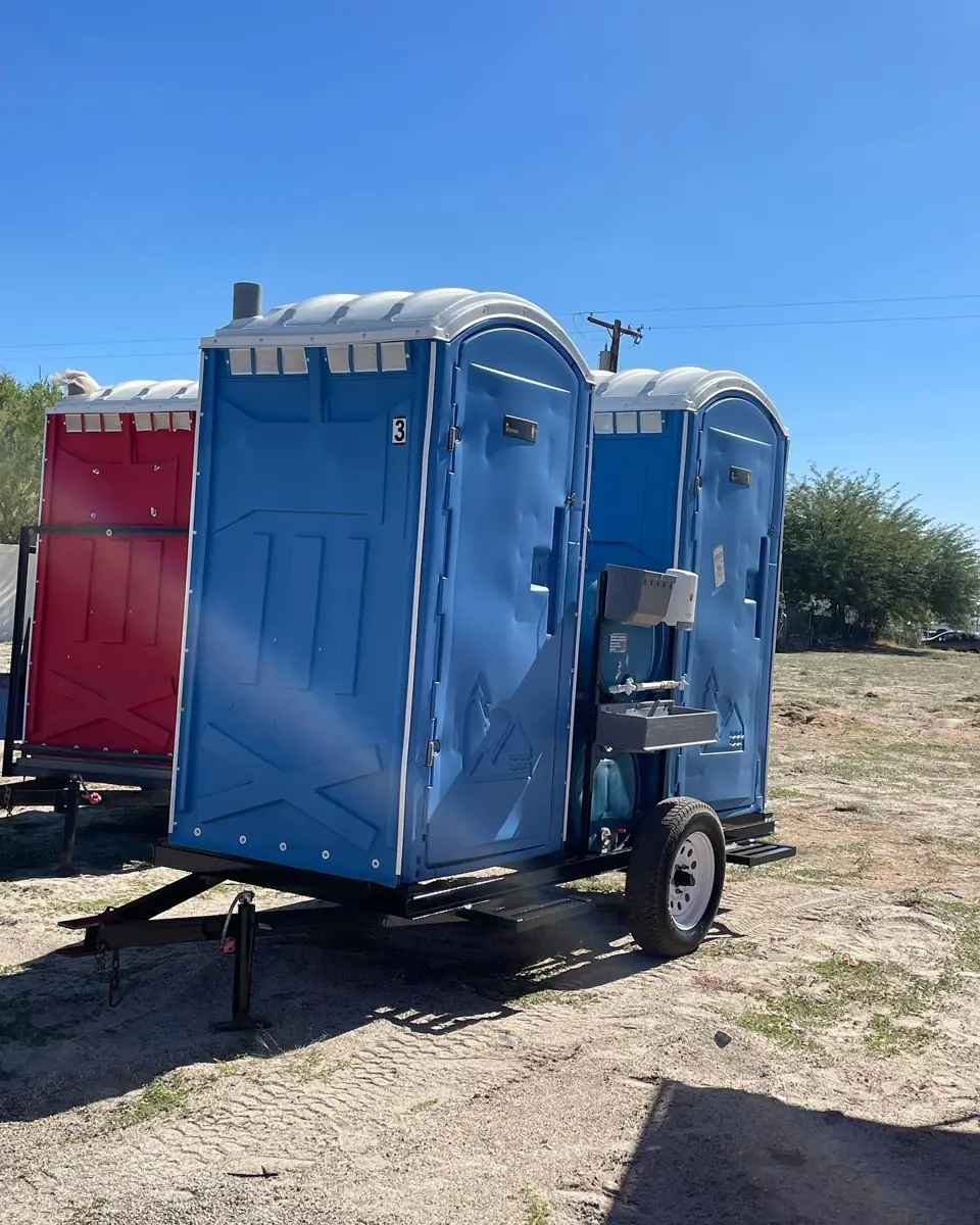 Blue portable toilet mounted on a small towable trailer